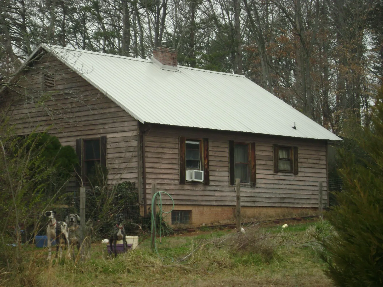 White metal roof on an old wood sided farmhouse, from a Metal Roof Installation job in Lake City